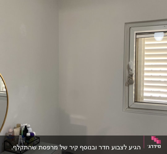 קיר צבוע בלבן עם חלון קטן